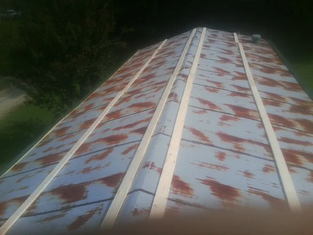 Rusted metal roof panels with new wood purlins before replacement — Storm Damage Roof Repair in Oxford by Roofing Brothers